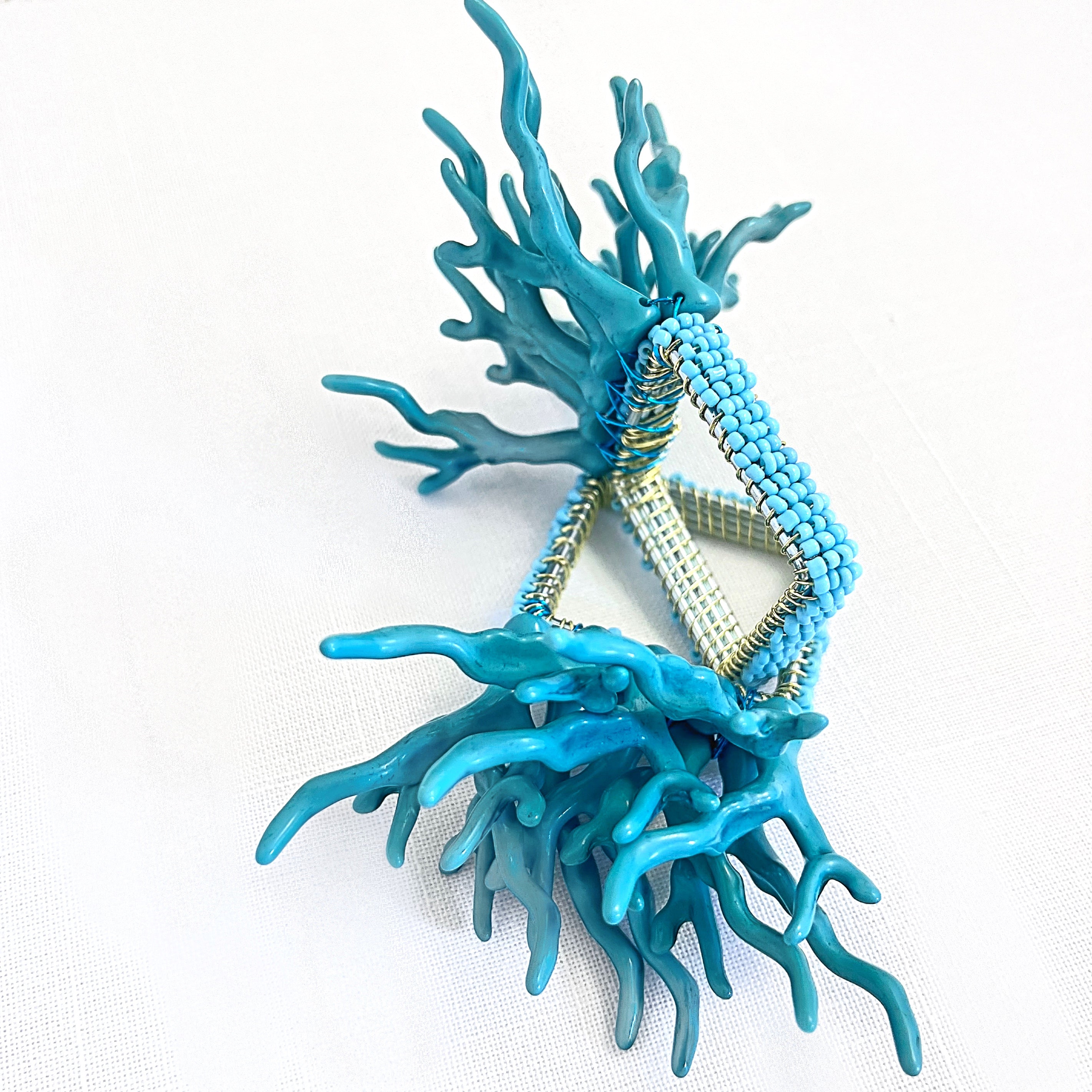 Tablescapes and table accessories, coral beaded napkin rings, linen napkins and placemats.